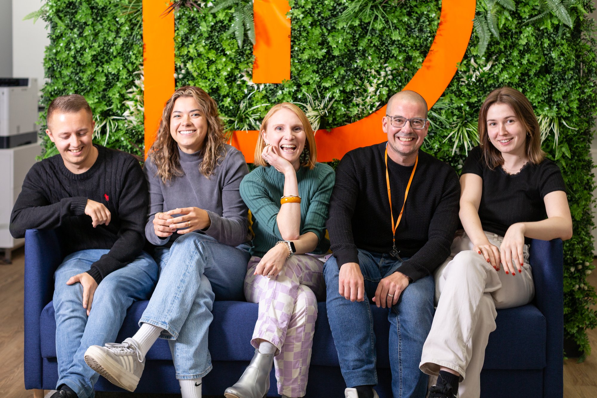 Resolve team laughing on a sofa in the office